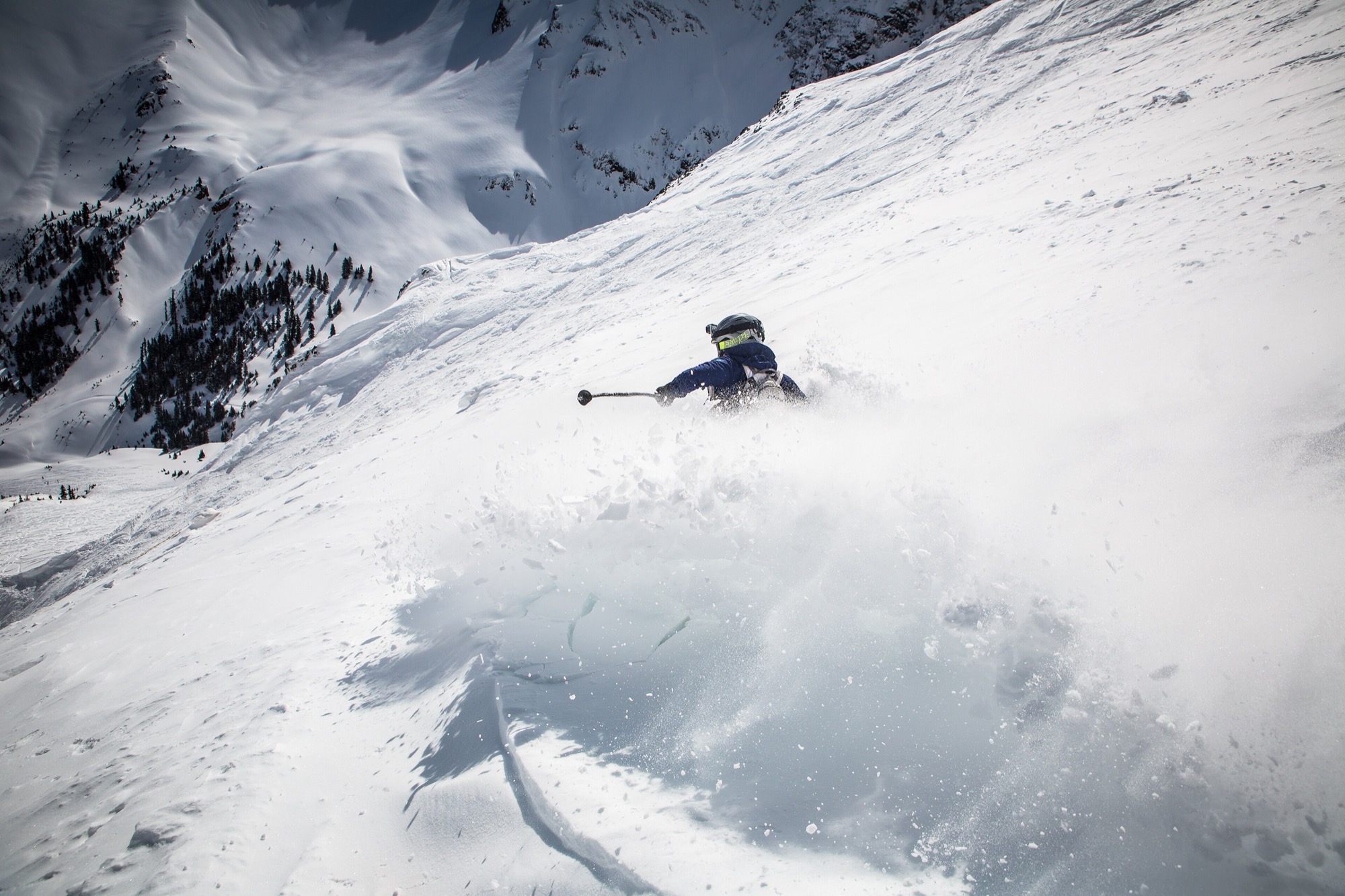 Skier carving a deep powder turn
