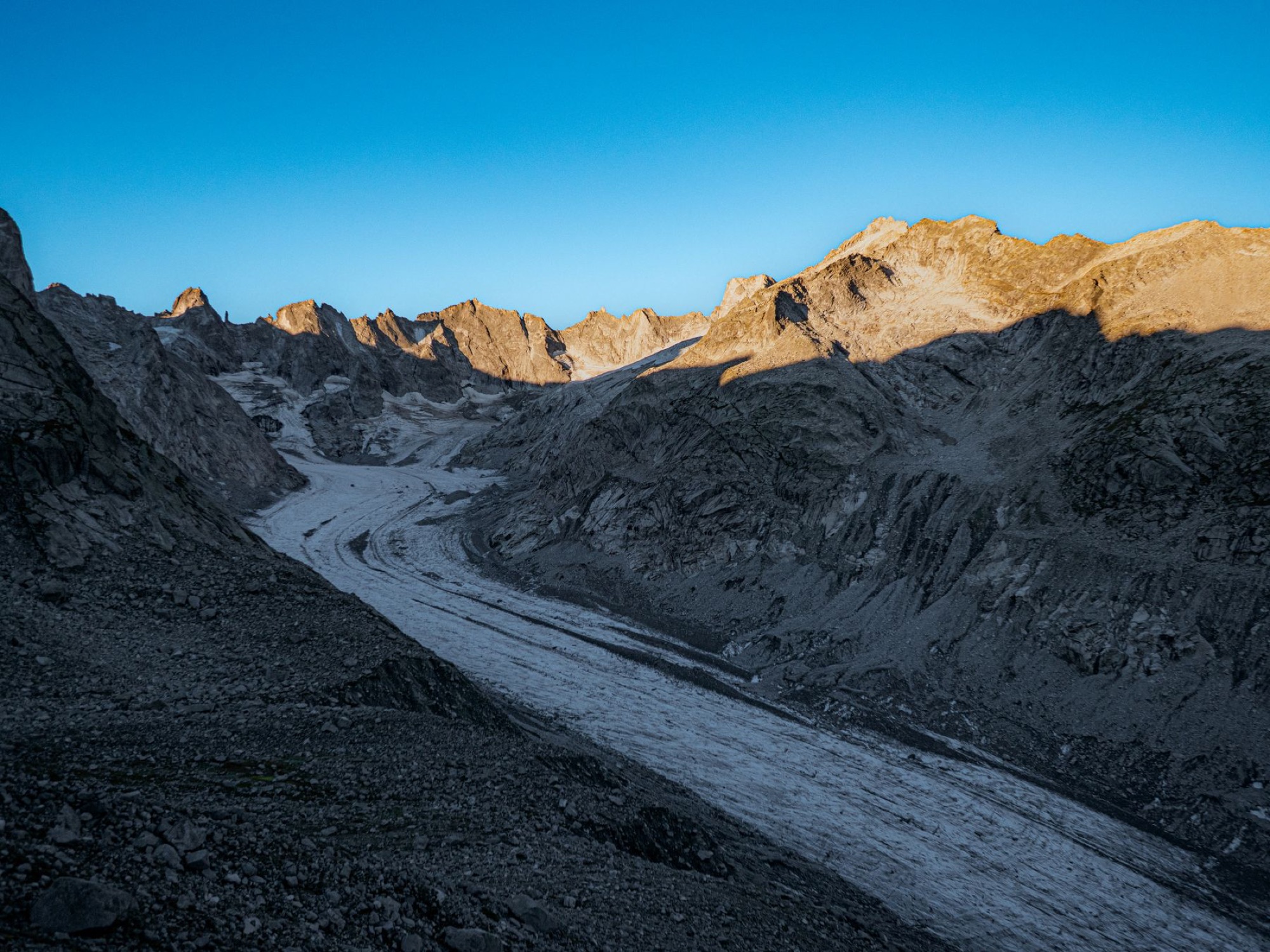 Rugged rocky peaks above a glacier valley at sunrise